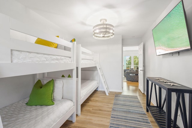 bedroom with a notable chandelier and light wood-type flooring