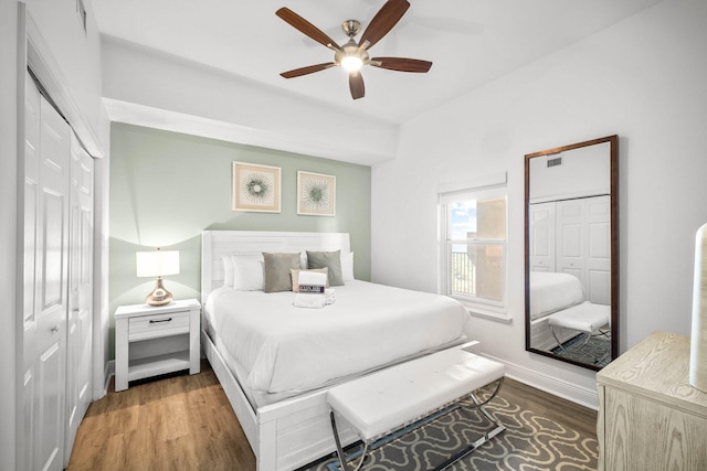 bedroom with ceiling fan, a closet, wood finished floors, and visible vents