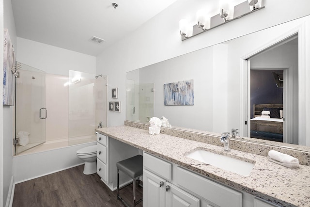 bathroom with toilet, wood finished floors, vanity, visible vents, and ensuite bath