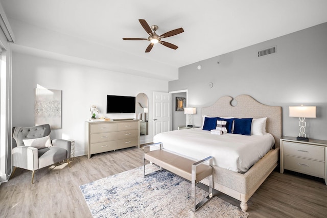 bedroom with baseboards, ceiling fan, visible vents, and wood finished floors