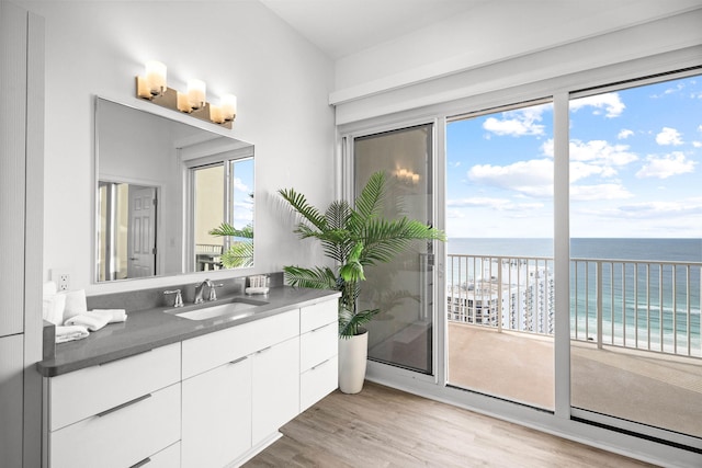 bathroom featuring plenty of natural light, a water view, wood finished floors, and vanity