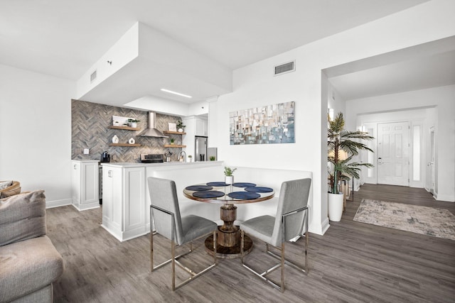 dining area with visible vents, baseboards, and wood finished floors