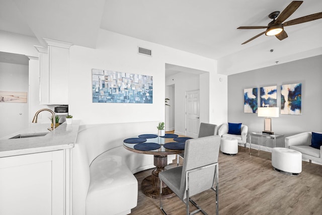 dining room featuring visible vents, ceiling fan, baseboards, and wood finished floors