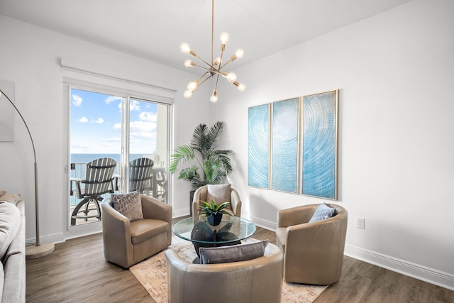 living area featuring an inviting chandelier, wood finished floors, and baseboards