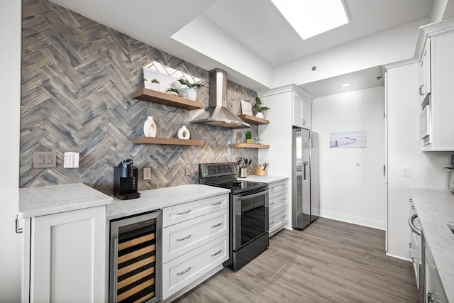 kitchen with beverage cooler, appliances with stainless steel finishes, wall chimney range hood, decorative backsplash, and open shelves