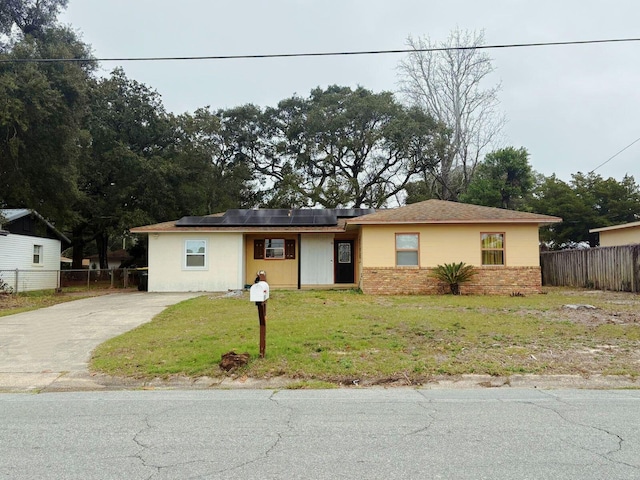 view of front of property featuring a front lawn and solar panels