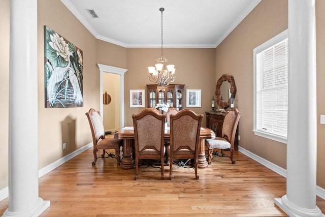 dining space featuring an inviting chandelier, ornamental molding, light hardwood / wood-style flooring, and ornate columns