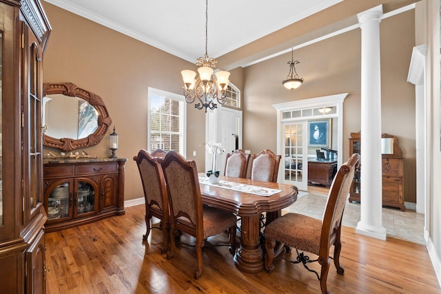 dining area with crown molding, light hardwood / wood-style flooring, and ornate columns