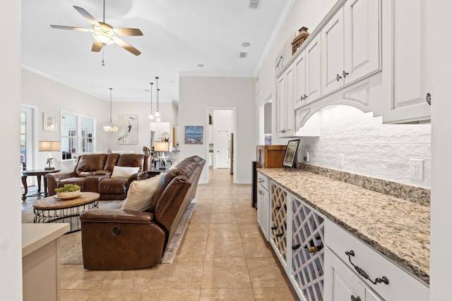 living room with ceiling fan, ornamental molding, and light tile patterned floors