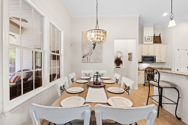 tiled dining room featuring ornamental molding and a chandelier