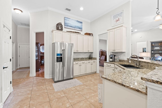 kitchen with sink, white cabinetry, light stone counters, decorative light fixtures, and high end refrigerator