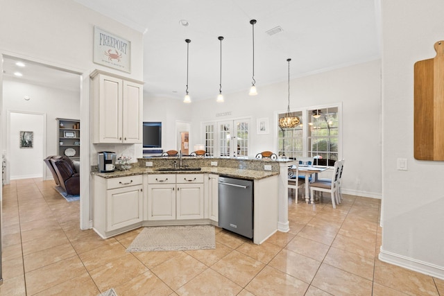 kitchen featuring hanging light fixtures, sink, stainless steel dishwasher, and dark stone counters