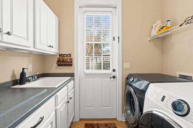 laundry room featuring cabinets, independent washer and dryer, and sink