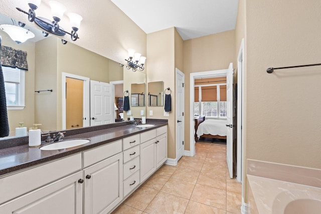 bathroom featuring tile patterned flooring, vanity, a washtub, and a chandelier