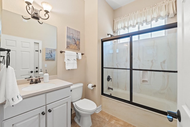 full bathroom with toilet, tile patterned floors, vanity, and shower / bath combination with glass door