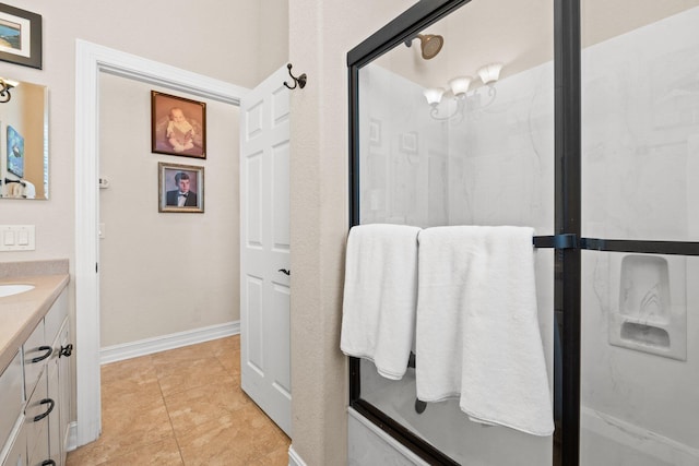 bathroom featuring vanity, a shower with shower door, and tile patterned floors