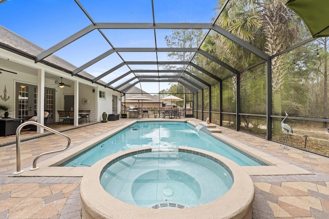 view of pool with an in ground hot tub, ceiling fan, a patio, and glass enclosure