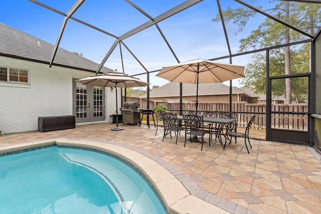 view of pool with french doors, a patio, and glass enclosure