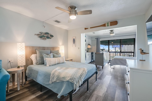 8730 Thomas Dr Unit 1307A, Panama City Beach, FL 32408 - bedroom with dark wood-style flooring, access to outside, freestanding refrigerator, a ceiling fan, and a textured ceiling