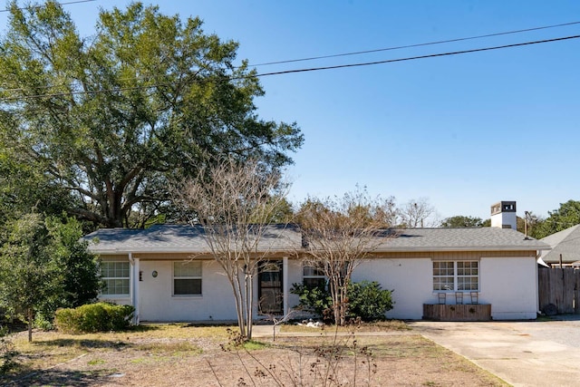 ranch-style house featuring fence and a chimney