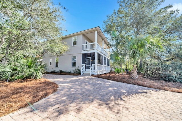 view of front of home featuring a sunroom and a balcony