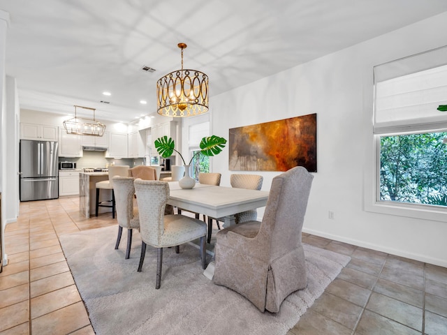 tiled dining space featuring a chandelier