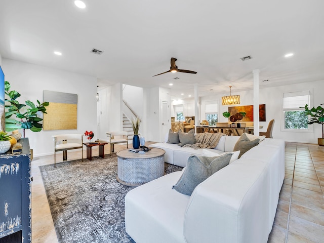 living room featuring ceiling fan, decorative columns, and light tile patterned floors