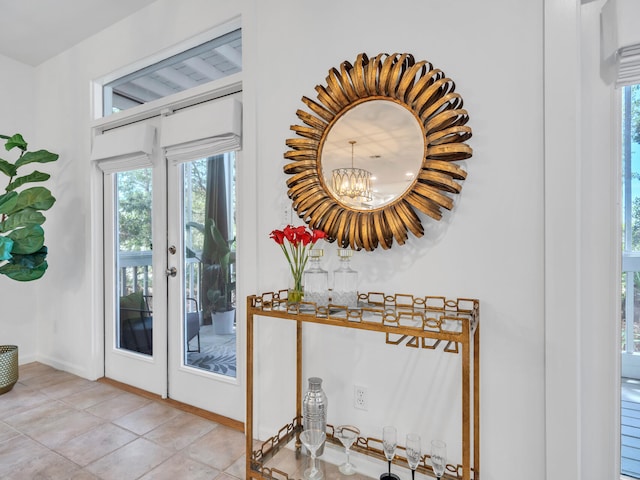 doorway with a notable chandelier and light tile patterned flooring