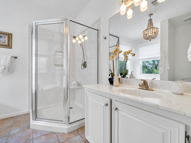 bathroom featuring tile patterned floors, vanity, a chandelier, and a shower with door