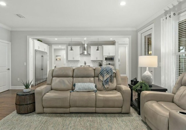 living room with sink, ornamental molding, and light wood-type flooring