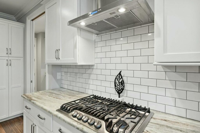 kitchen featuring white cabinetry, decorative backsplash, stainless steel gas cooktop, light stone counters, and wall chimney range hood