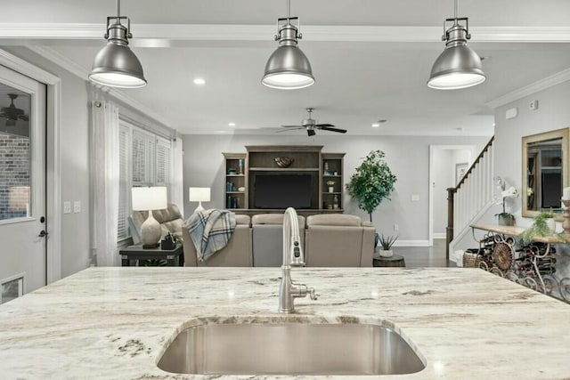 kitchen with pendant lighting, sink, and light stone countertops