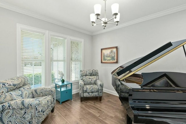 sitting room with crown molding, hardwood / wood-style floors, and an inviting chandelier