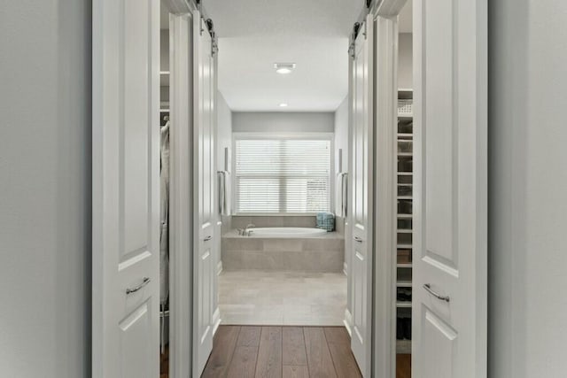 hallway with dark hardwood / wood-style flooring and a barn door