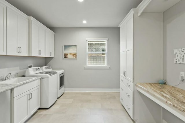 laundry area featuring cabinets, sink, and washer and clothes dryer