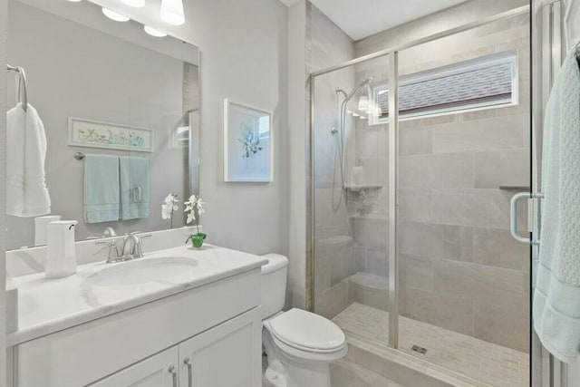 bathroom featuring vanity, an enclosed shower, and toilet