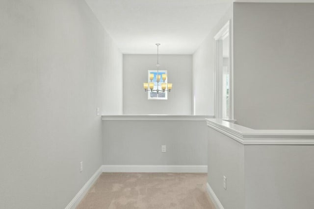 unfurnished dining area with light colored carpet and an inviting chandelier