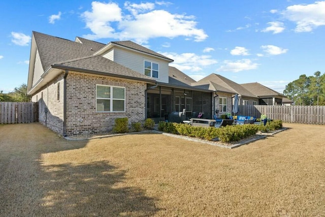 rear view of property featuring a yard, a patio area, and a sunroom