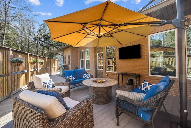 wooden deck featuring an outdoor living space with a fire pit and a grill