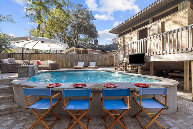 view of swimming pool featuring fence, an outdoor living space, a fenced in pool, and a patio