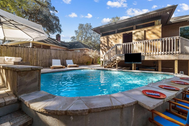 view of pool featuring a patio, fence, outdoor dry bar, stairs, and a fenced in pool