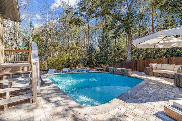 view of pool featuring a patio, outdoor lounge area, fence, and a fenced in pool