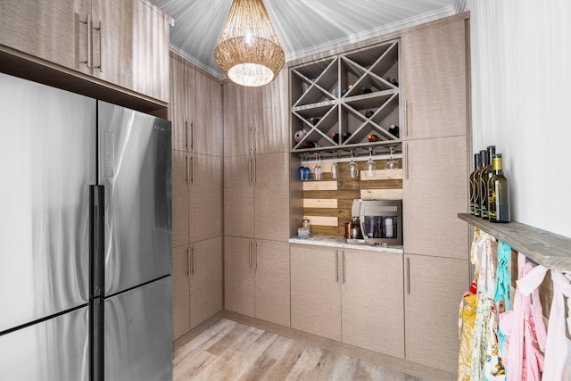 kitchen with light wood finished floors, light countertops, an inviting chandelier, freestanding refrigerator, and modern cabinets