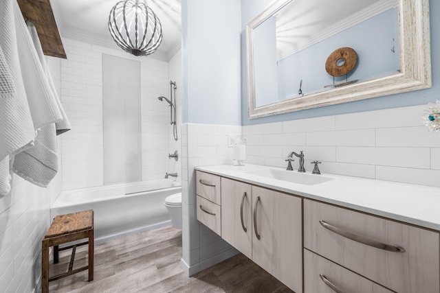 bathroom featuring tile walls, shower / bathing tub combination, toilet, vanity, and wood finished floors