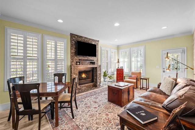 living area with a fireplace, baseboards, crown molding, and recessed lighting