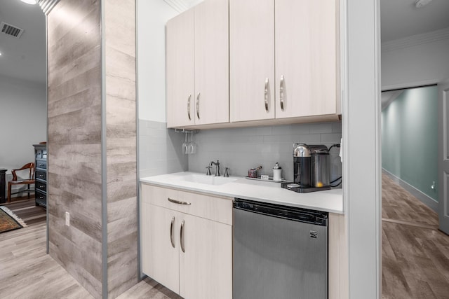 kitchen featuring dishwashing machine, light countertops, visible vents, and crown molding