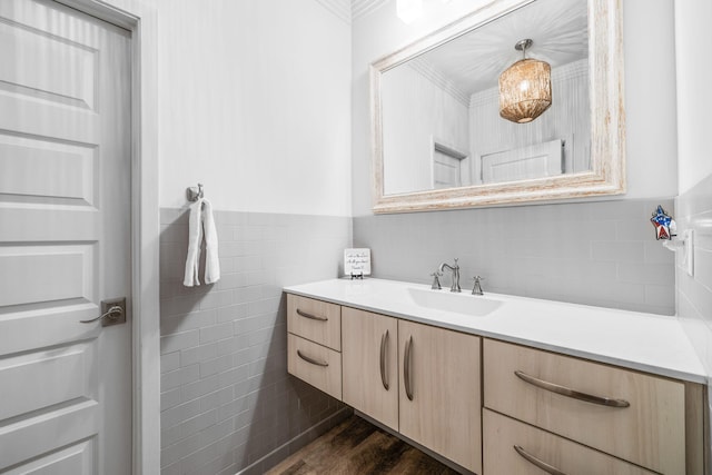 bathroom featuring tile walls, wainscoting, vanity, and wood finished floors