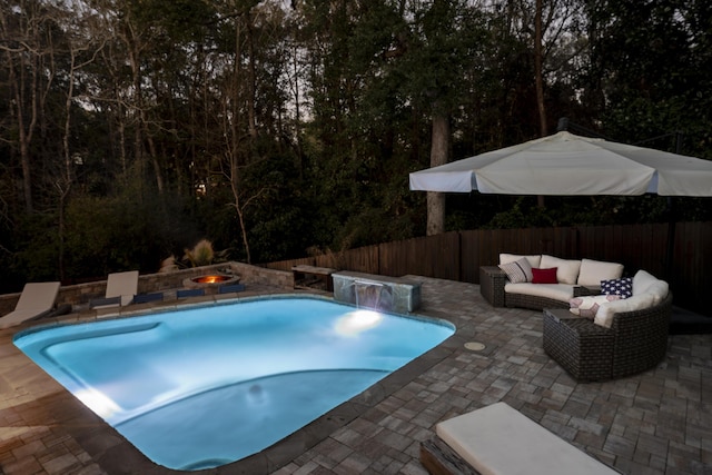 view of pool with a fenced backyard, a patio area, an outdoor living space with a fire pit, and a fenced in pool