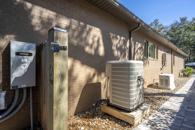 view of property exterior featuring brick siding and central air condition unit