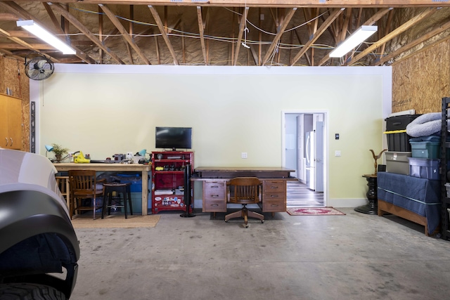 garage featuring freestanding refrigerator and a workshop area